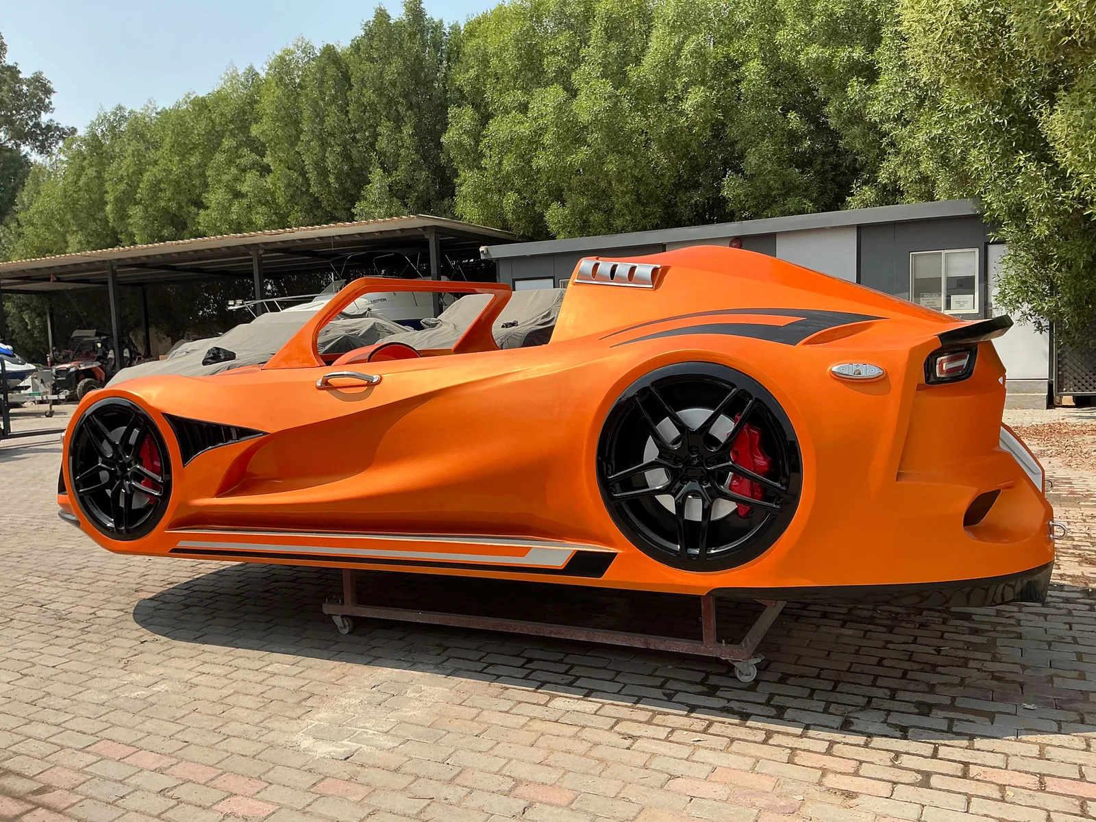 Orange Super Water Car rear three-quarter view at the manufacturing facility